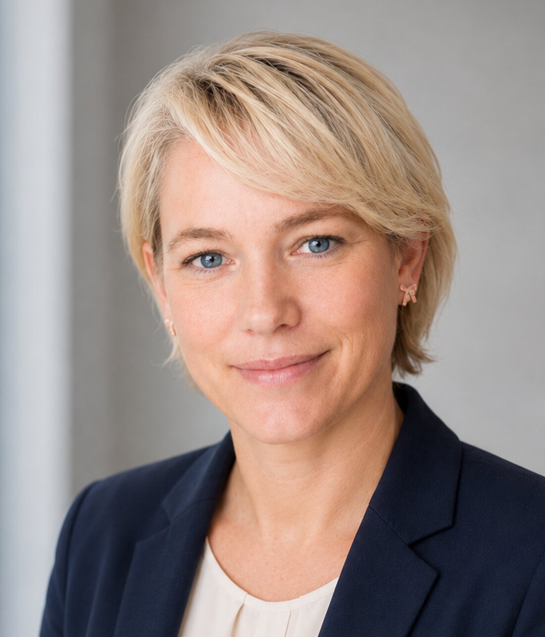 Porträt von Anna Maria Kaufmann im marineblauen Blazer vor hellem Studiohintergrund